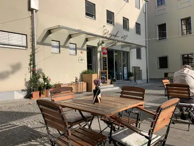 a wooden table and chairs in front of a building at Hisa Gradnikova in Tolmin