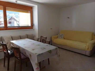 a living room with a table and a couch at OASIS in Bovec