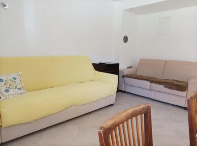 a living room with a yellow couch and a chair at OASIS in Bovec
