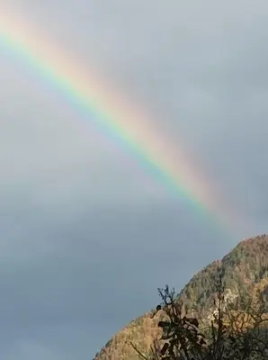 a rainbow in the sky over a mountain at OASIS in Bovec