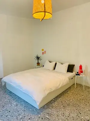 a bedroom with a large white bed with a lamp at Samson and the Lilo in Vipava