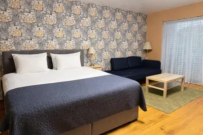a bedroom with a bed and a blue couch at Villa Tatjana in Rogaška Slatina