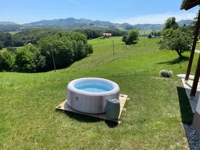 a large bath tub sitting in the grass at Holiday House Zlačka Gorca in Pristava pri Mestinju