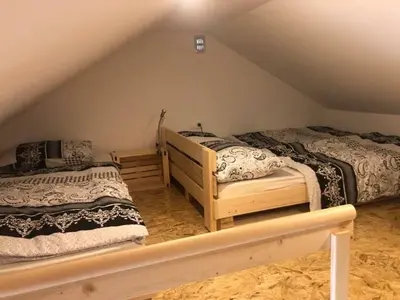 a attic bedroom with two beds in a attic at Holiday House Zlačka Gorca in Pristava pri Mestinju