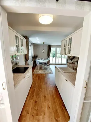 a kitchen with white cabinets and a table at Villa Rory in Bled