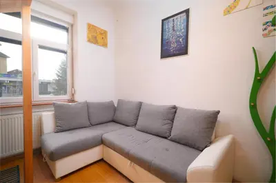 a living room with a couch and a window at Urban view apartment with free parking in Ljubljana