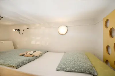 a bedroom with a bed with a light on the wall at Urban view apartment with free parking in Ljubljana