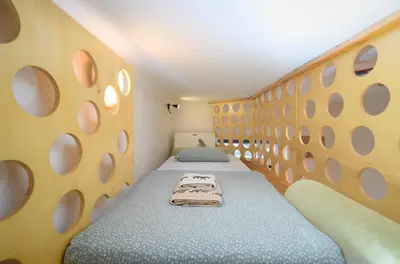 a bedroom with two beds and a wall with circles at Urban view apartment with free parking in Ljubljana