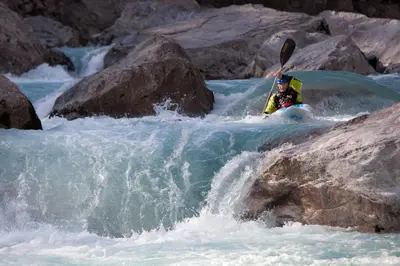 a person in a kayak in a rapids in a river at Počitniška HIŠKA POLOVNIK in Bovec
