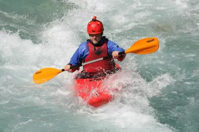 a man in a red kayak in the water at Počitniška HIŠKA POLOVNIK in Bovec