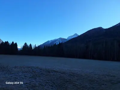 a large open field with mountains in the background at Apartma Aurora in Kranjska Gora