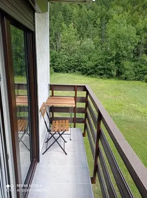 a porch with a wooden table and a bench at Apartma Aurora in Kranjska Gora
