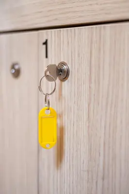 a yellow key chain attached to a wooden door at Boutique Hostel Angel in Ljubljana