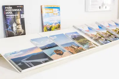 a display of photographs on a table with books at Boutique Hostel Angel in Ljubljana