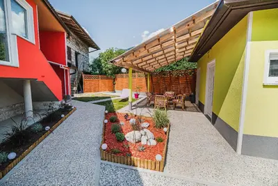 a patio with a garden with a table and chairs at CUDERLAND -CUKR in Kobarid