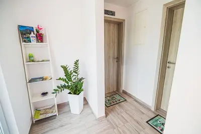 a hallway with a potted plant and a door at CUDERLAND -CUKR in Kobarid