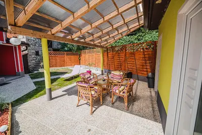 a patio with a table and chairs under a pergola at CUDERLAND -CUKR in Kobarid