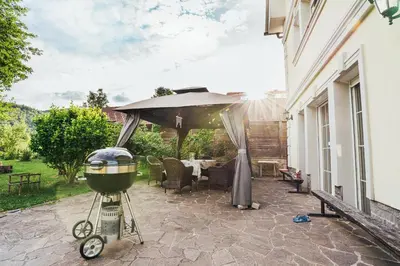 a grill sitting on a patio under an umbrella at Apartment Sneznik in Stari Trg pri Ložu