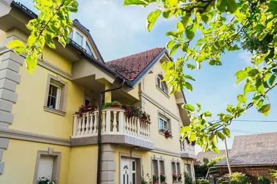 a yellow house with a balcony at Apartment Sneznik in Stari Trg pri Ložu