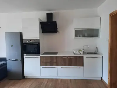 a kitchen with white cabinets and a refrigerator at Apartma Maks & Anita in Bovec