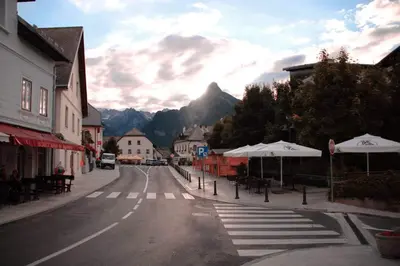 an empty street with tables and umbrellas in a town at Apartma Maks & Anita in Bovec