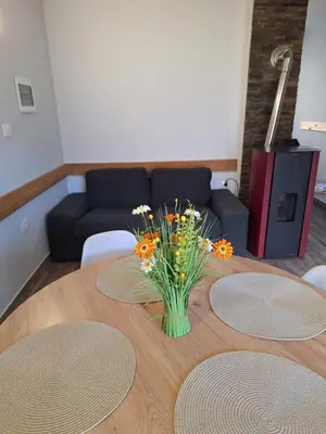 a wooden table with a vase of flowers on it at Apartma Maks & Anita in Bovec