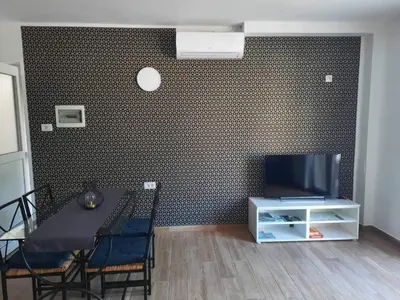 a dining room with a table and a tv on a wall at Apartma Maks & Anita in Bovec