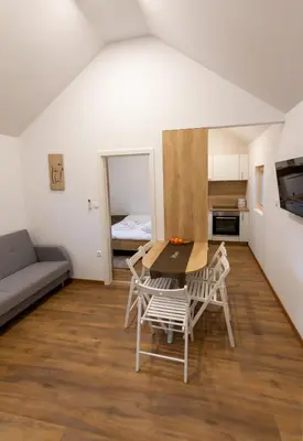a living room with a table and chairs and a couch at Ribiška vasica - Fishermen's Village in Radeče