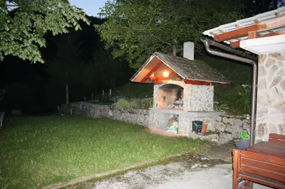 a stone fireplace in the yard of a house at Dream Apartment Brglez in Bohinjska Bela