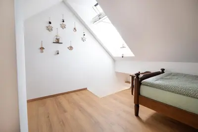 a bedroom with a bed and a white wall at Apple tree apartment in Bled