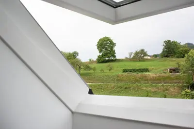 a window in a white house with a view of a field at Apple tree apartment in Bled