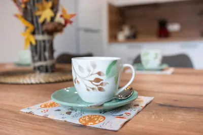 a coffee cup on a napkin on a table at Apple tree apartment in Bled