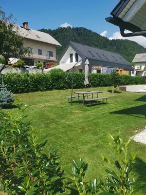a park with a picnic table and an umbrella at Apple tree apartment in Bled