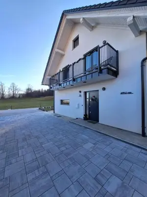 a white building with a balcony and a patio at Apple tree apartment in Bled