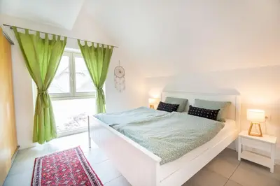 a white bed in a room with a window at Apple tree apartment in Bled