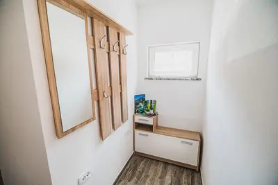 a hallway with a mirror and a drawer and a window at CUDERLAND STUDIO KURNIK in Kobarid