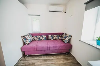 a purple couch in a room with a window at CUDERLAND STUDIO KURNIK in Kobarid