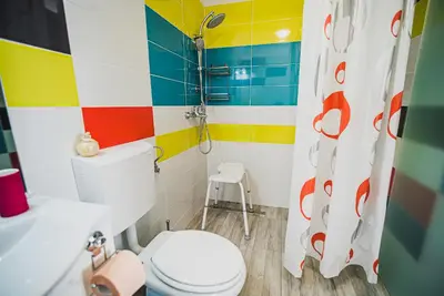 a colorful bathroom with a toilet and a sink at CUDERLAND STUDIO KURNIK in Kobarid