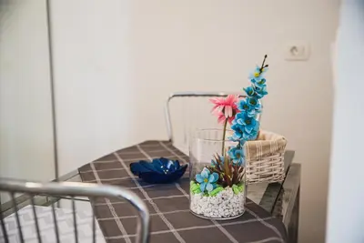 a table with a glass vase with flowers on it at CUDERLAND STUDIO KURNIK in Kobarid