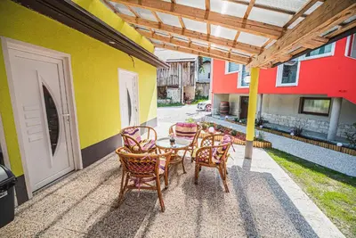a patio with a table and chairs on a building at CUDERLAND STUDIO KURNIK in Kobarid