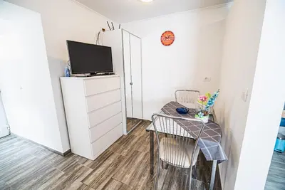 a small room with a tv and a table and chair at CUDERLAND STUDIO KURNIK in Kobarid