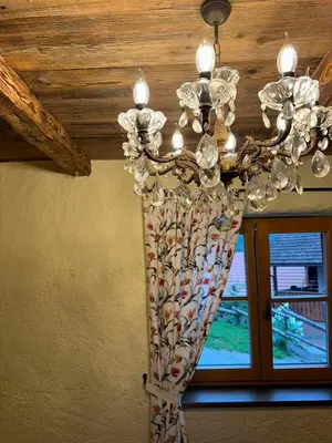 a chandelier hanging from a ceiling with a window at Rose garden in Ljubno