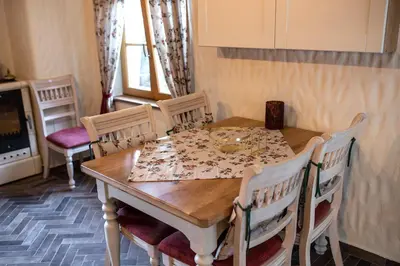 a dining room table with chairs and a table and a table and chairs at Rose garden in Ljubno