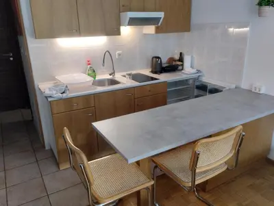 a kitchen with a counter and a sink and two chairs at Studio Kaninska vas in Bovec