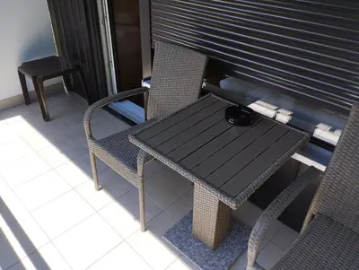 a table and chairs on a balcony with a blind at Studio Kaninska vas in Bovec