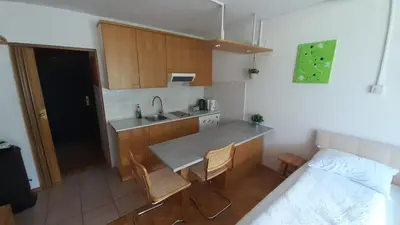 a kitchen with a table and chairs and a bed at Studio Kaninska vas in Bovec