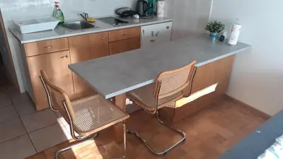 a kitchen with a counter with two chairs and a table at Studio Kaninska vas in Bovec