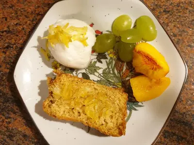 a white plate of food with a piece of bread and fruit at B&B Margarita in Cerkovna