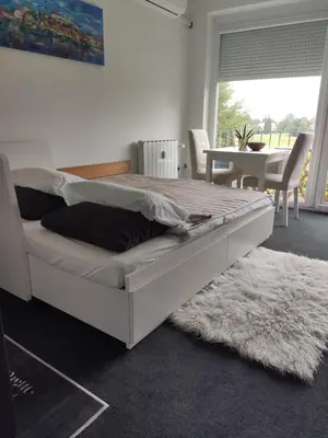 a white bed in a room with a table and chairs at Studio apartment 