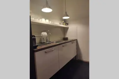 a kitchen with white cabinets and a sink at Studio apartment 